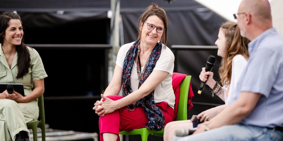 FEZ-Geschäftsführerin Dr. Margrit Witzke sitzt beim Kindertagsfest 2025 auf der Bühne.